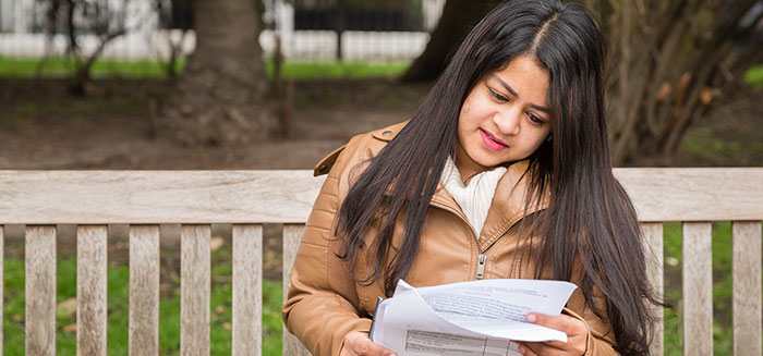 A CCLS student sat on a bench in Lincoln's Inn Fields reading