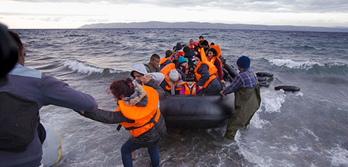 Refugees landing on a shore in a boat