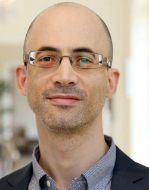 The profile picture for Dr Hedi Viterbo. It is a close-up profile shot. Dr Viterbo has a closely-shaven head and wears rimless glasses and a grey collared shirt.