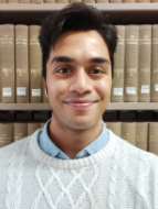 A profile picture of Dr Tanzil Chowdhury. He is wearing a light blue collared shirt with a white jumper. He has dark hair and light brown skin. He is smiling.