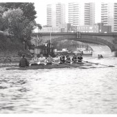 Students rowing near a bridge