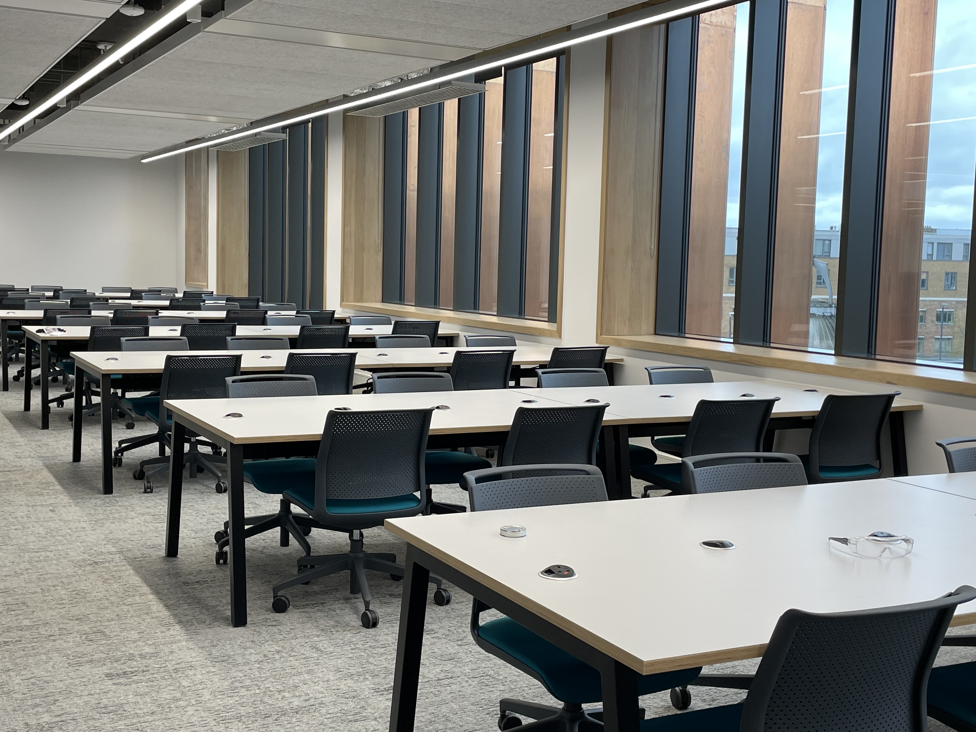 Study desks and chairs lined up along a wall