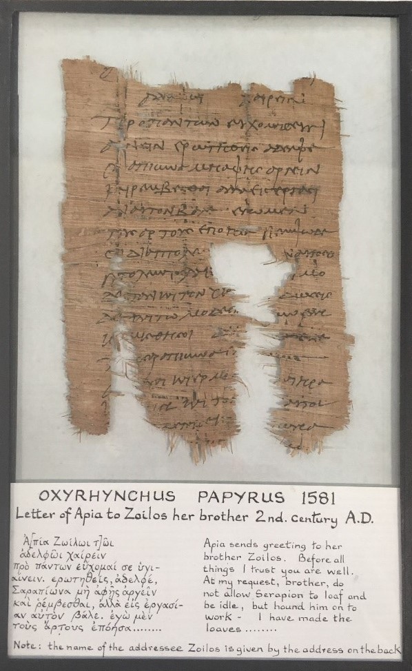 Image of papyrus document in frame in ancient Greek characters with an English translation below.