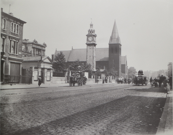 Photographic negative of People's Palace, frontage on Mile End Road, showing cobbled road with horse drawn carriages and St Benets Church in background