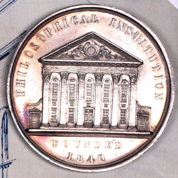 Silver medal with engraving of Beaumont Institute and engraved text which reads: Philosophical Institution founded 1840.