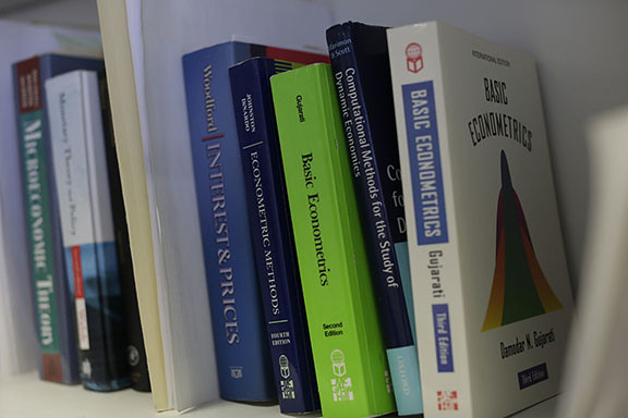 Economics textbooks sitting on a shelf