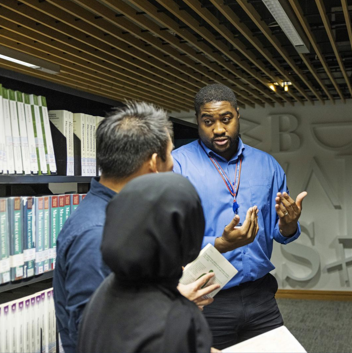 a member of Library staff having a discussion with students