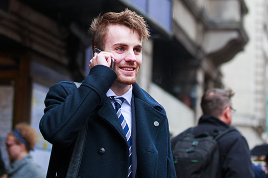 Student on the phone walking out of Holborn tube station