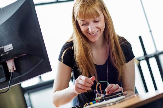 Female student using electronic engineering equipment
