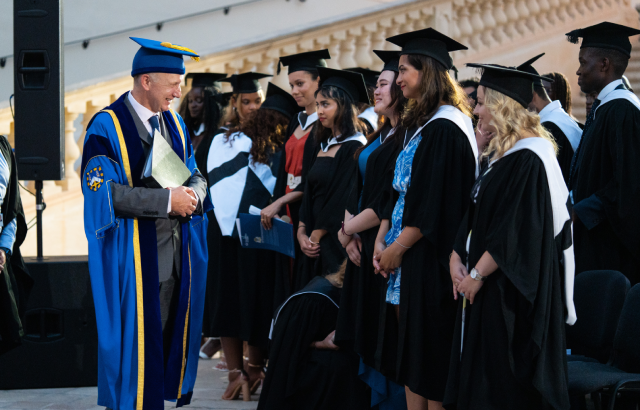 Professor Colin Bailey greeting students at the Queen Mary, Malta Graduation