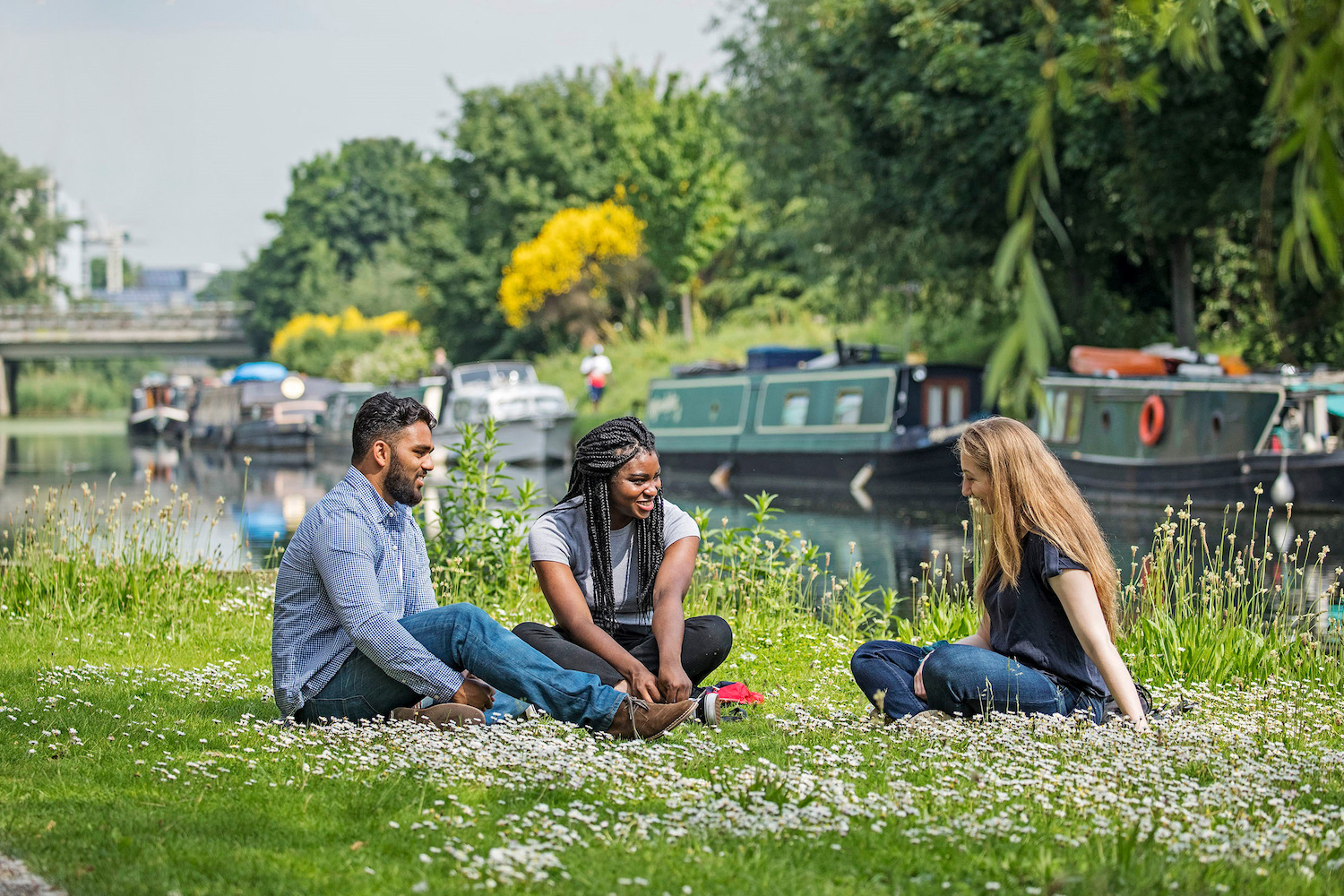 Students sitting by canal