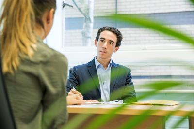 Two people in a discussion with leaves in the foreground