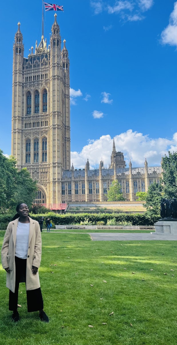 Mary Ojo standing on the lawn outside the houses of parliament