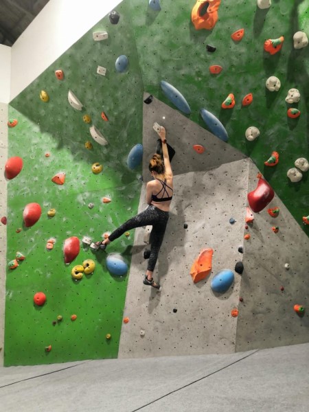 Photo of alumna, Lara Conboy, on a climbing wall