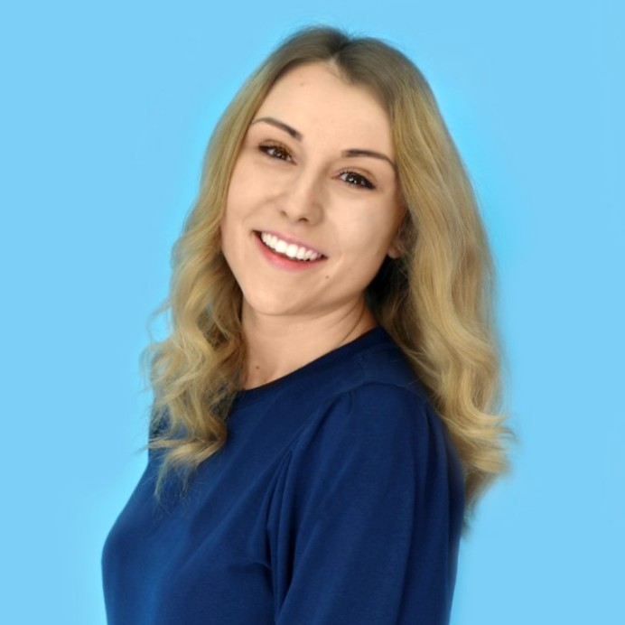 Headshot of alumna, Laura Mucklow, against a blue backdrop