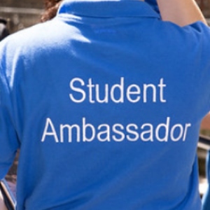 Person wearing blue t-shirt with the words 'student ambassador'