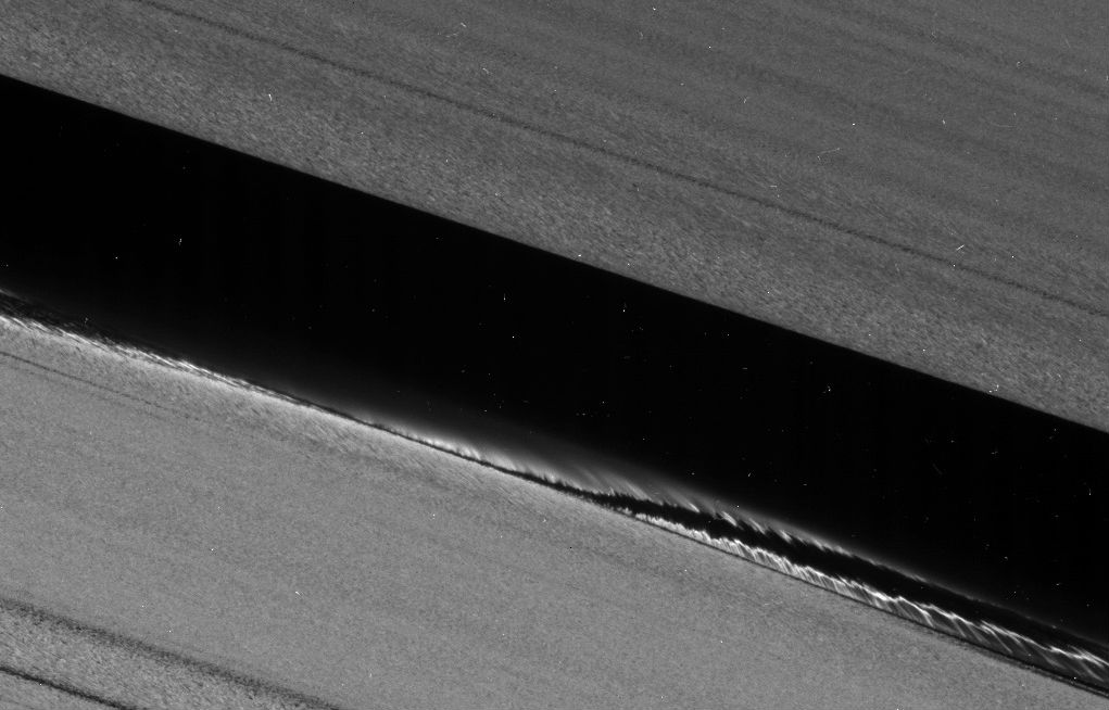 A false-color image mosaic shows Daphnis, one of Saturn's ring-embedded moons, and the waves it kicks up in the Keeler gap. Images collected by Cassini's close orbits in 2017 are offering new insight into the complex workings of the rings. Image Credit: NASA/JPL-Caltech/Space Science Institute 