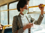 Black woman travelling by bus wearing protective face mask. Credit: Drazen Zigic/ iStock.com