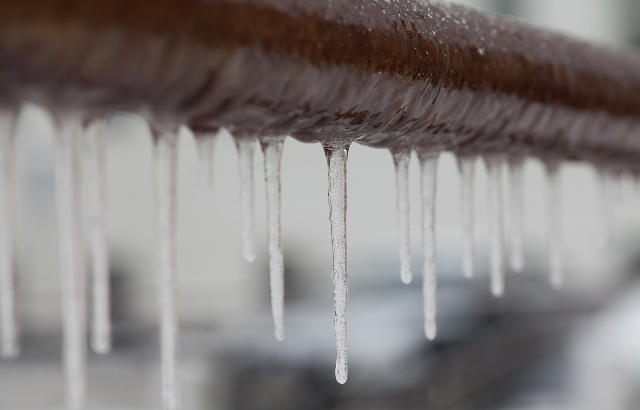 Icicles hanging from a pipe. Credit: Besjunior/iStock.com.