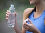 Woman holding plastic water bottle after workout. Credit: JohnnyGreig/iStock.com.