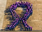People form a purple ribbon to raise awareness for domestic violence