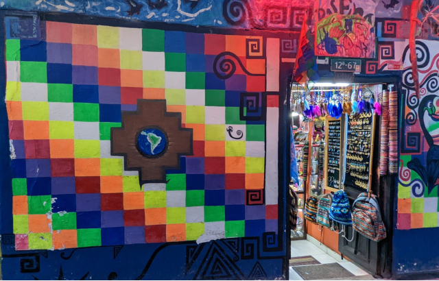 Colourful Latin American wall covering and building behind with open door