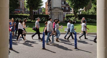 Students walking past Queens' Building