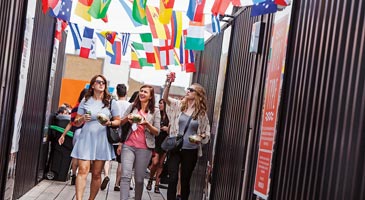 QMUL students walking under country flags