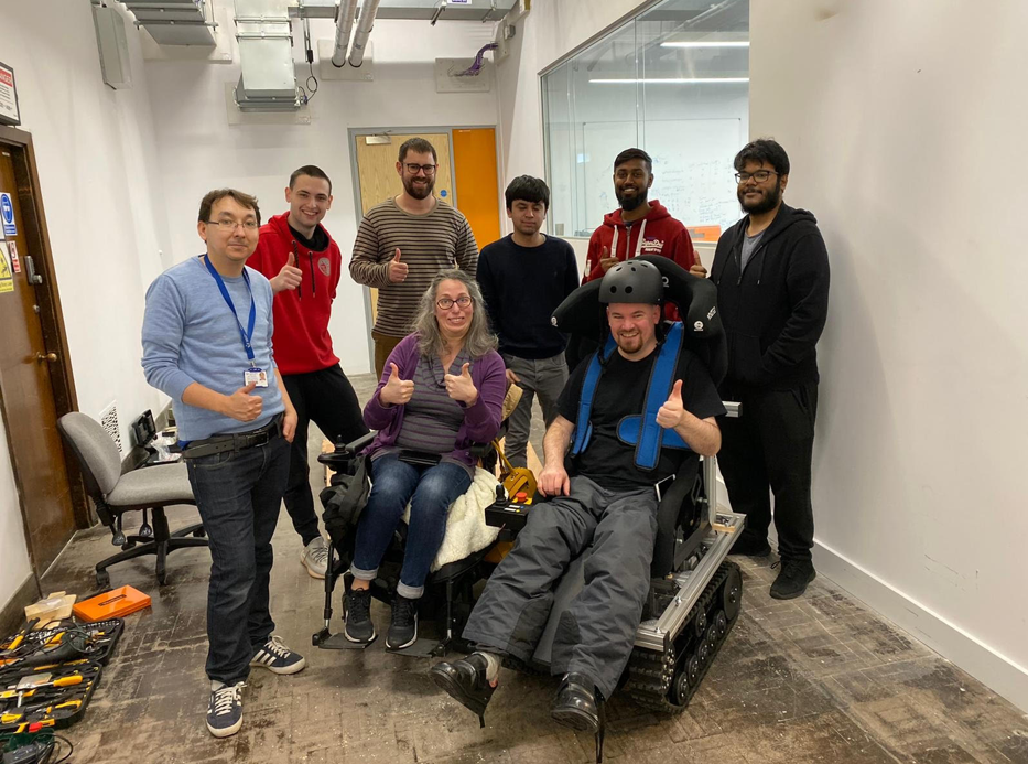 Group photograph of students, staff, and wheelchair users working on the development of assistive technologies together