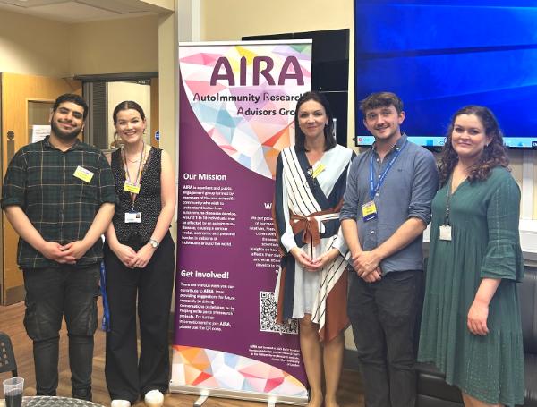 The organisers of the AIRA Science Day 2025 stand next to an AIRA banner