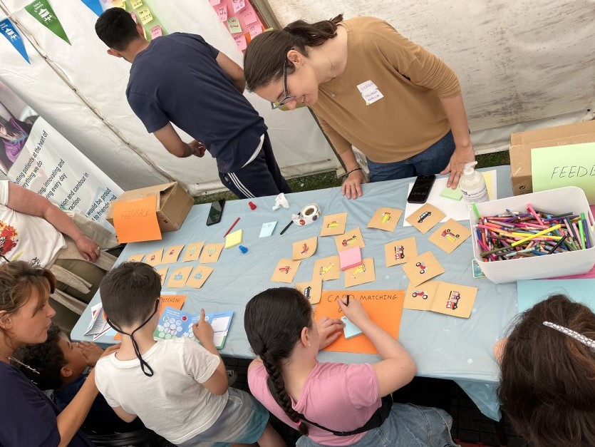Children playing a card matching game with researchers at the Festival of Communities