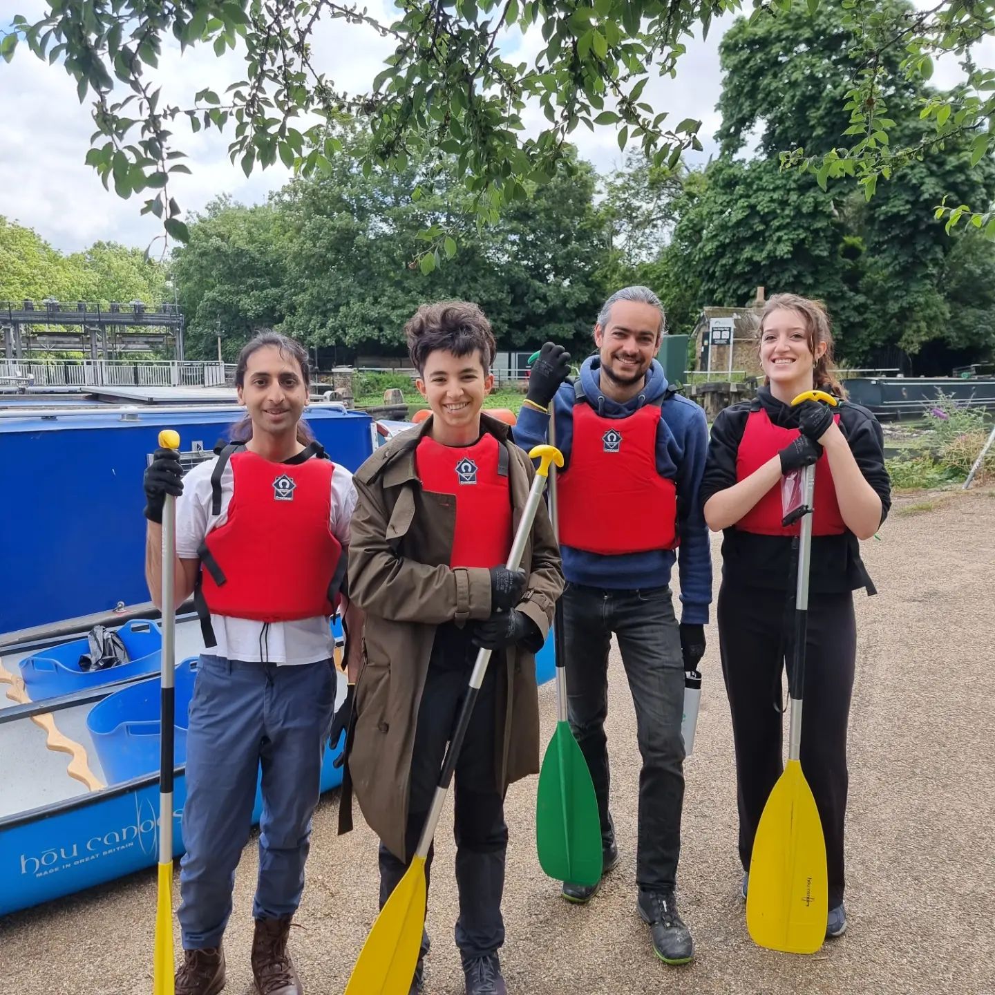 Students and staff next to the canal with buoyancy aids and paddles after litter picking in the River Lea.
