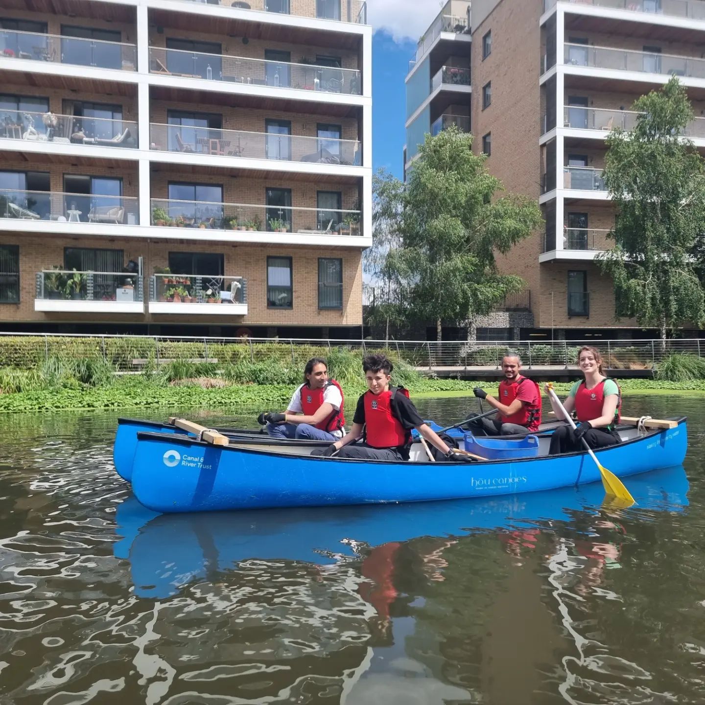 Students and staff in drafted canoes paddling around the River Lea collecting litter.