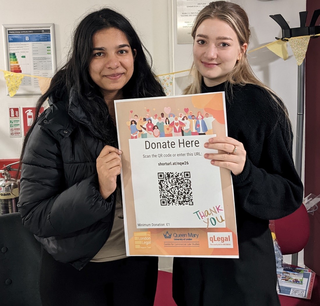 Two members of qLegal team holding donation poster