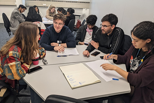 A table of students having a discussion at the qLegal Bootcamp 2022