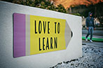 A sign on a university campus saying 'love to learn'