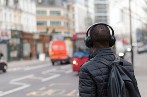 Person wearing headphones crossing the street