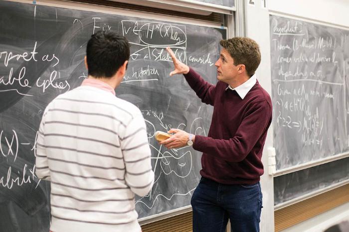 Two people standing at a blackboard