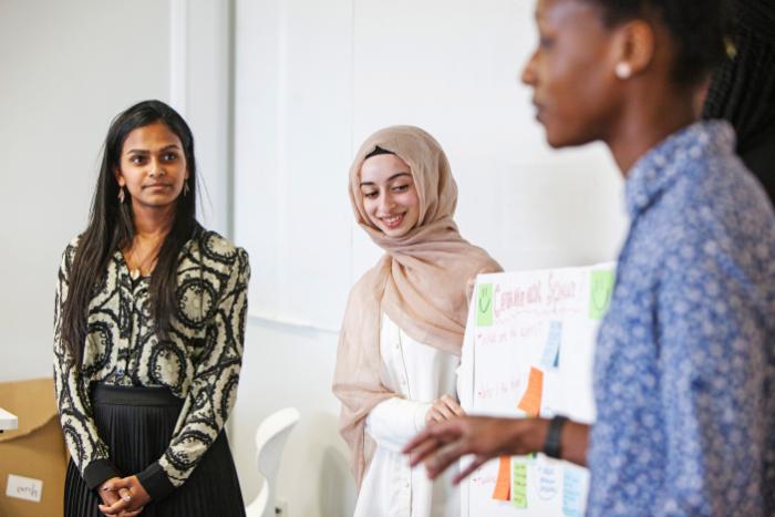 Three female students standing to make a presentation