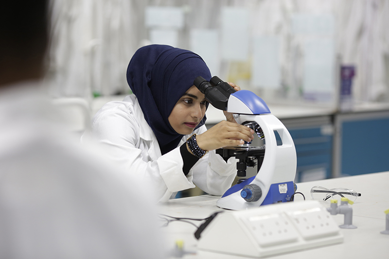 A female researcher using a microscope