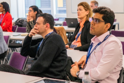 A group of conference delegates listening to a presentation