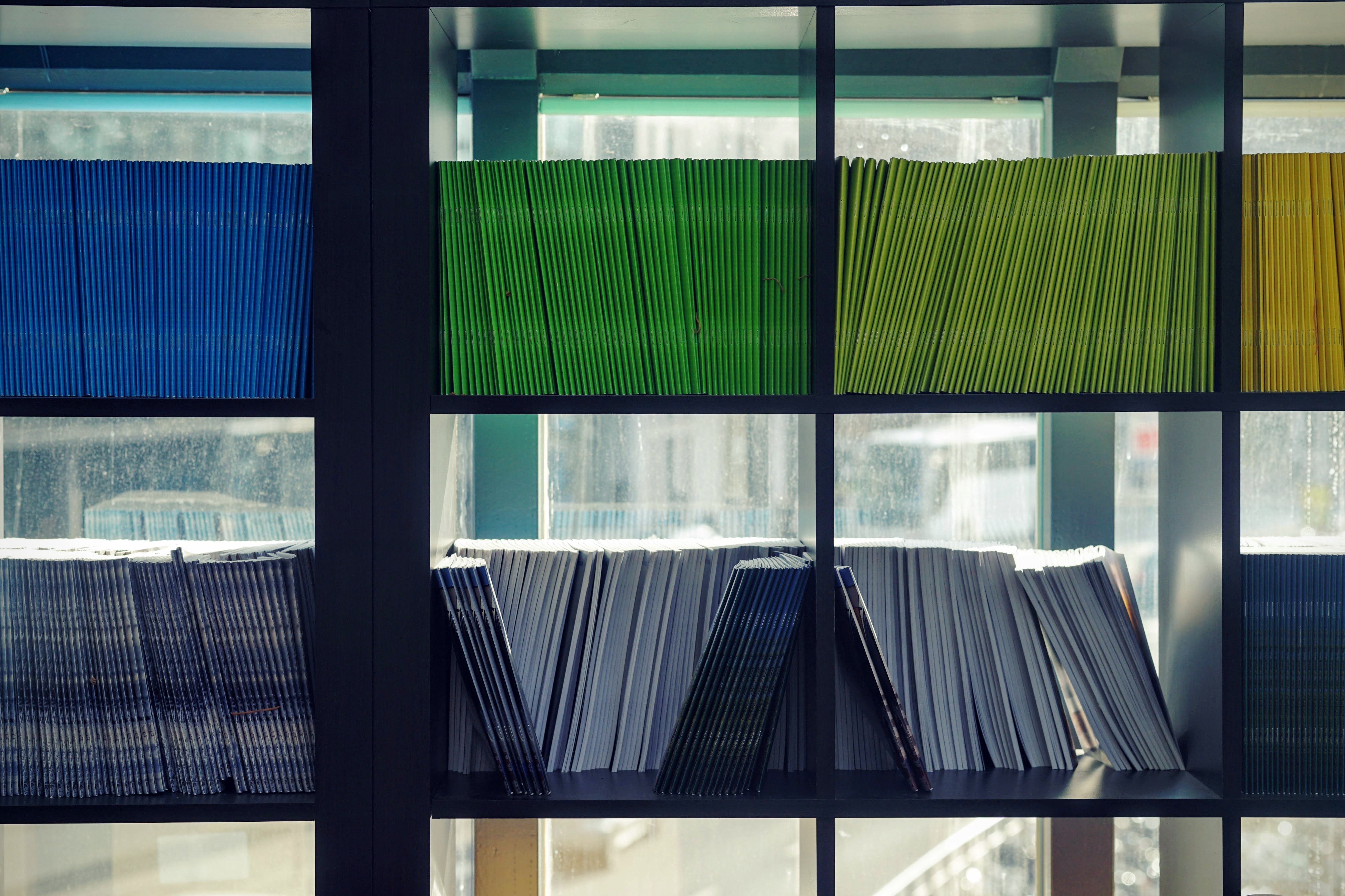 Open book shelves with books arranged to show different colours of the spines