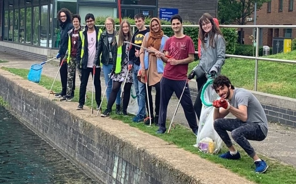 A group of Queen Mary students standing on the bank of the canal at Mile End
