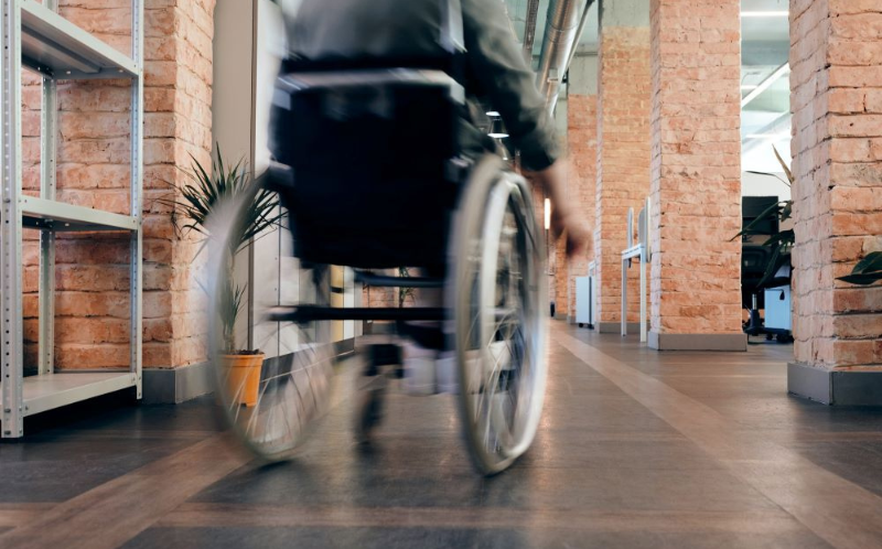 An image of a wheelchair user moving along a corridor