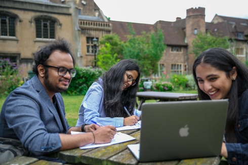 Three students sitting outside at Charterhouse Square working together