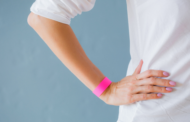 pink wristband on woman's arm with rather stylish matching nail polish