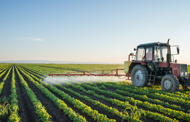 Tractor spraying pesticides on a field