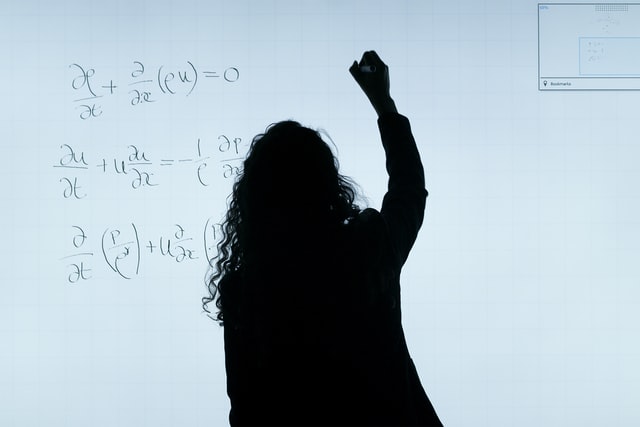 Female Silhouette Writing Equations on Whiteboard