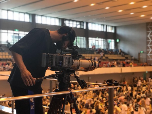 Photo of alumnus, Matt Kay, filming at a sumo competition