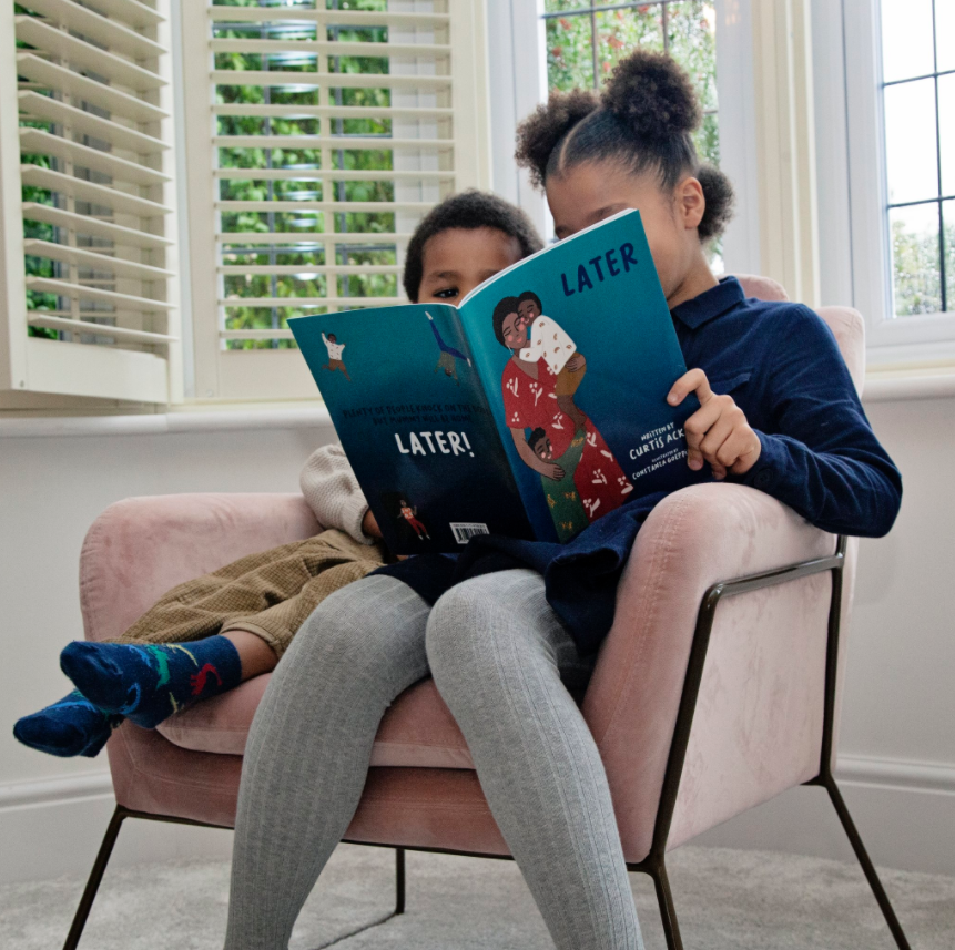 Child and woman reading picture book together in a chair